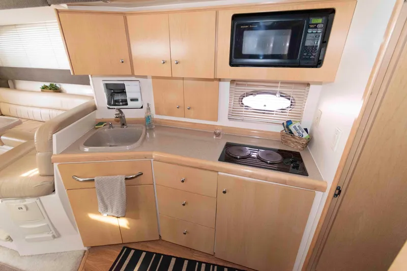 Slide: The Image of 1997 Carver 350 Mariner kitchen with microwave, stove, and sink in a compact layout. - 18