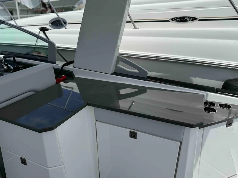 Slide: The Image of 2023 Aviara AV32 OB boat interior with sleek countertop and storage compartments. - 12