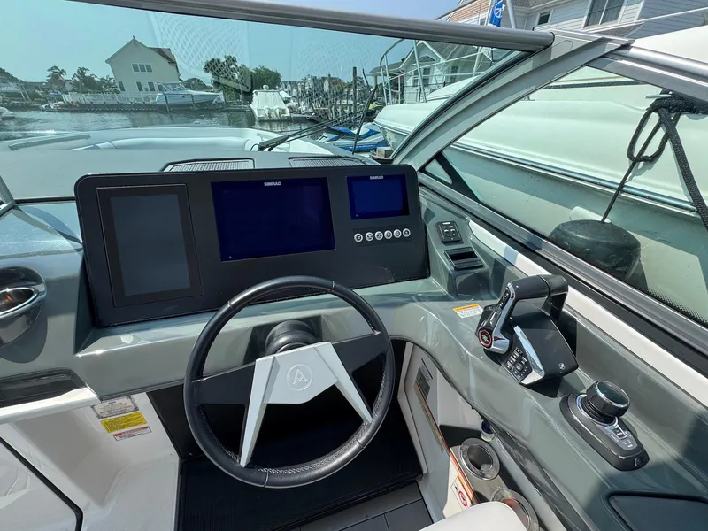 Slide: The Image of 2023 Aviara AV32 OB boat dashboard with steering wheel and control panel. - 14