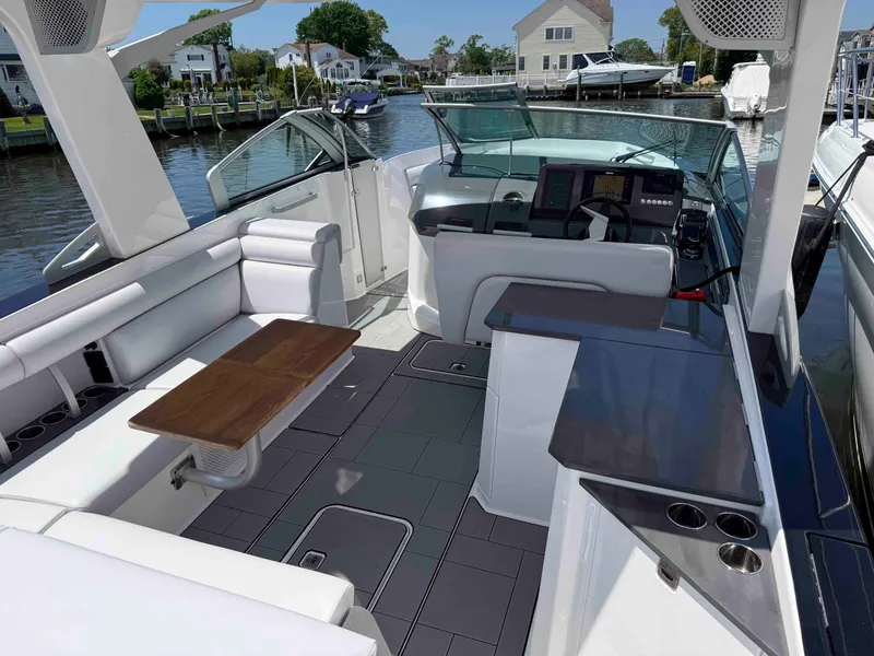 Slide: The Image of 2023 Aviara AV32 OB luxury boat interior with seating, table, and control panel. - 2