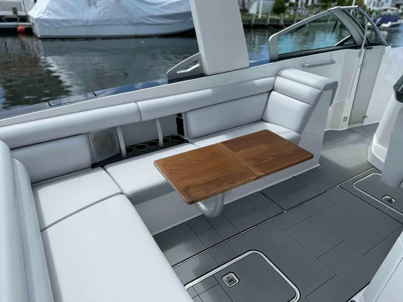 Slide: The Image of 2023 Aviara AV32 OB boat interior with white seating and wooden table. - 4