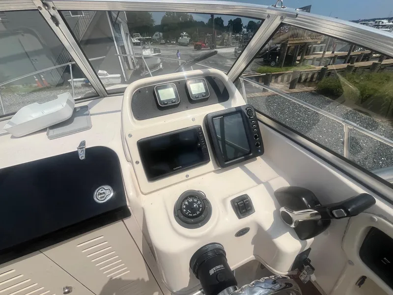 Slide: The Image of 2006 Grady-White Adventure 208WA boat dashboard with navigation instruments and steering wheel. - 15