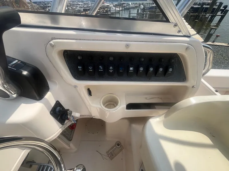 Slide: The Image of Control panel of a 2006 Grady-White Adventure 208WA boat, featuring various switches. - 16