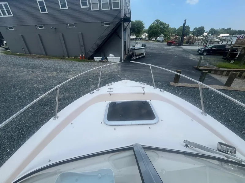 Slide: The Image of 2006 Grady-White Adventure 208WA boat docked near a marina with clear sky. - 23