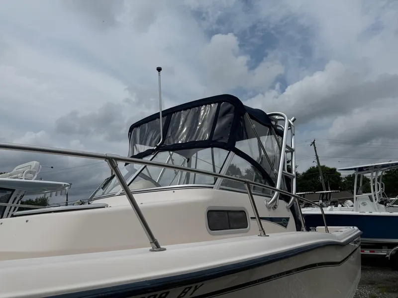 Slide: The Image of 2006 Grady-White Adventure 208WA boat with canopy under cloudy sky. - 26