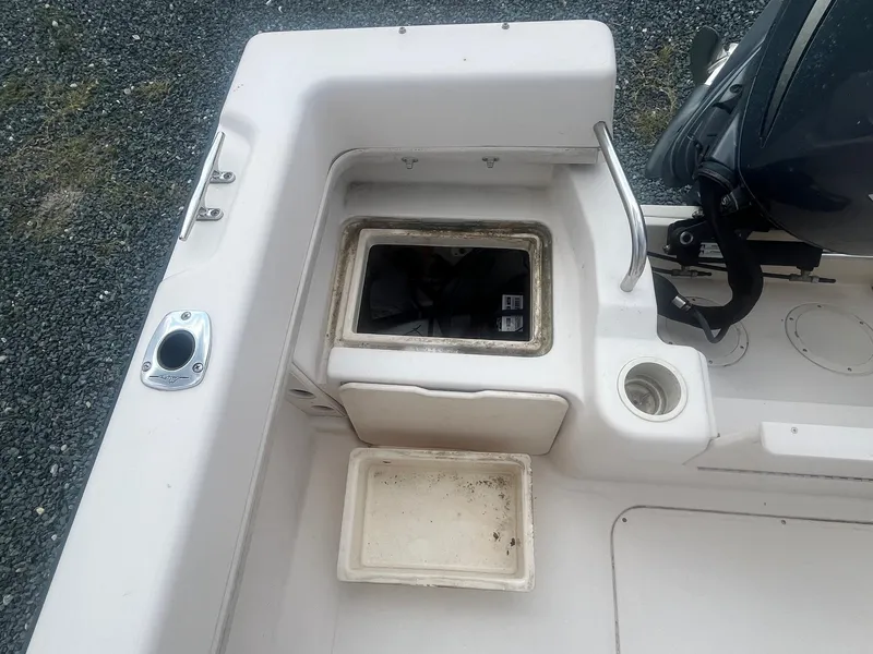 Slide: The Image of 2006 Grady-White Adventure 208WA boat interior with storage compartments and engine. - 8