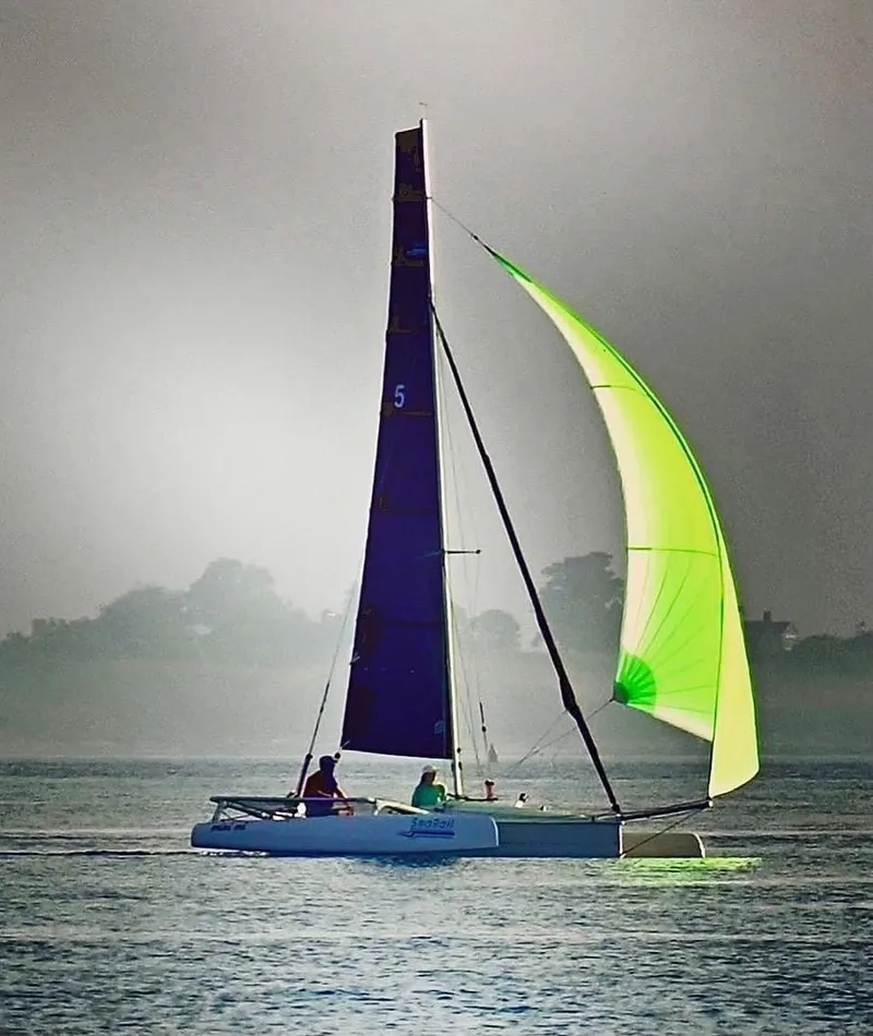 The Image of Trimaran SeaRail 19 sailing with vibrant green sail on calm waters, 2014 model. - 0