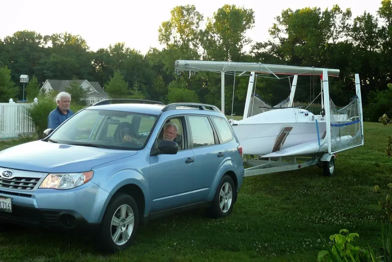 Slide: The Image of Blue SUV towing a 2014 Trimaran SeaRail 19 on a grassy field. - 13