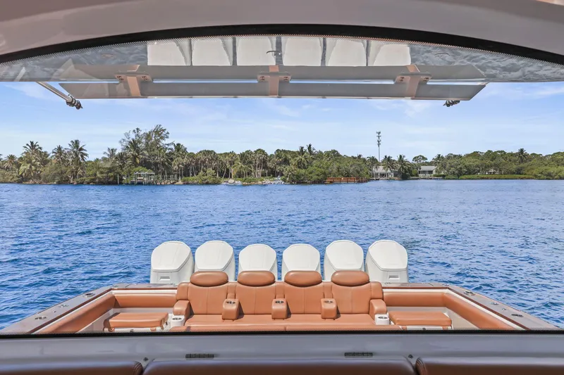 Slide: The Image of 2023 HCB 65 Estrella yacht with luxurious seating, overlooking serene blue waters and lush greenery. - 17