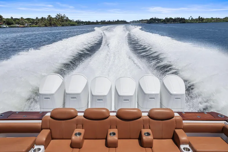 Slide: The Image of 2023 HCB 65 Estrella boat with six powerful engines cruising on a scenic waterway. - 19