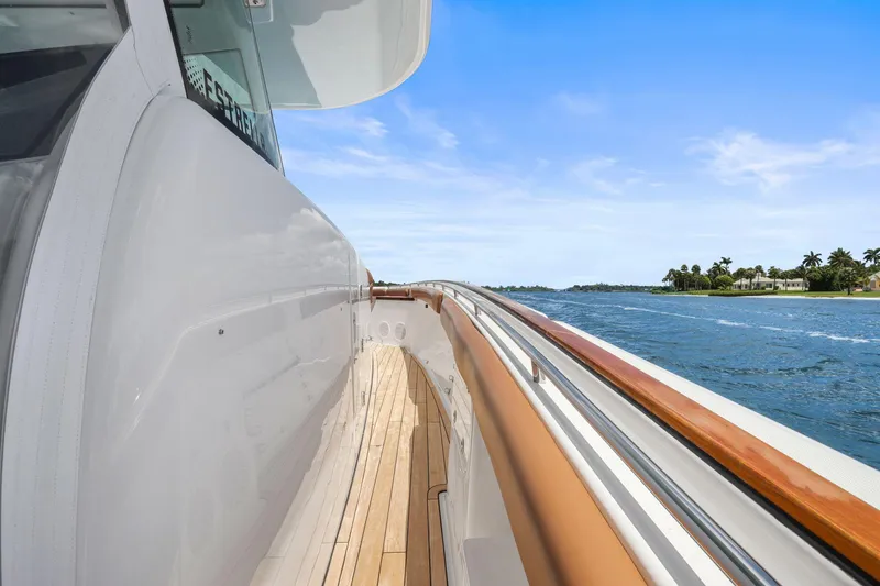 Slide: The Image of 2023 HCB 65 Estrella yacht cruising on a sunny day, showcasing sleek design and wooden deck. - 28