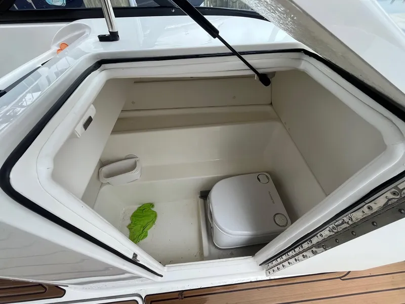Slide: The Image of 2023 Bayliner VR6 Bowrider OB storage compartment with portable toilet and cleaning supplies. - 10