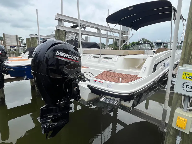 Slide: The Image of 2023 Bayliner VR6 Bowrider OB with Mercury outboard engine docked at marina. - 2
