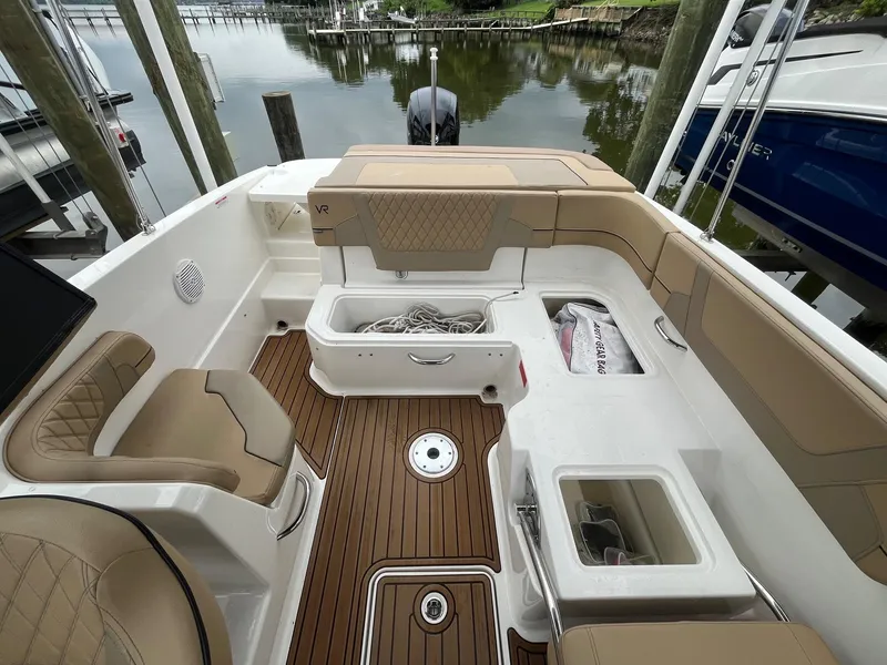 Slide: The Image of 2023 Bayliner VR6 Bowrider OB interior with tan seating and wood-style flooring. - 4
