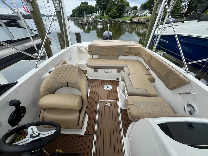Slide: The Image of 2023 Bayliner VR6 Bowrider OB interior with tan seating and wood-style flooring. - 5