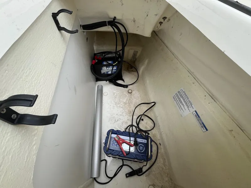 Slide: The Image of 2023 Bayliner VR6 Bowrider OB storage compartment with battery and cables. - 7