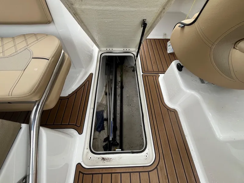 Slide: The Image of 2023 Bayliner VR6 Bowrider OB interior storage compartment with teak flooring and beige seating. - 9