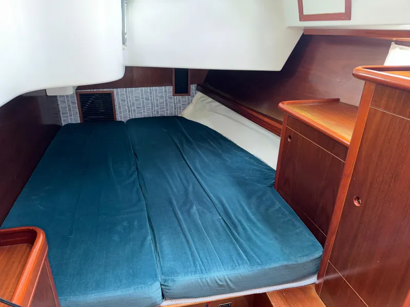 Slide: The Image of 1997 Beneteau Oceanis 461 cabin interior with blue bedding and wooden cabinetry. - 12