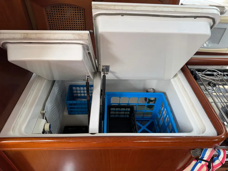 Slide: The Image of Open refrigerator on 1997 Beneteau Oceanis 461 yacht, featuring organized storage baskets. - 16