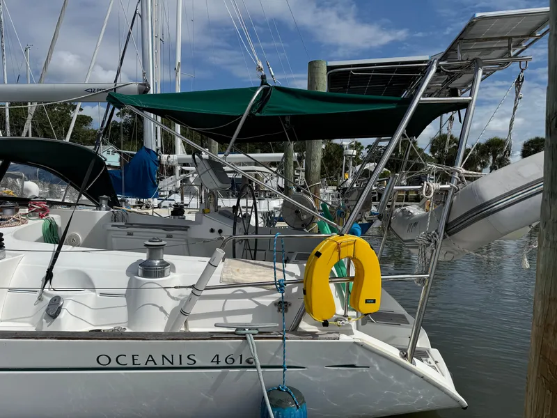 Slide: The Image of 1997 Beneteau Oceanis 461 sailboat docked, featuring green canopy and solar panels. - 21