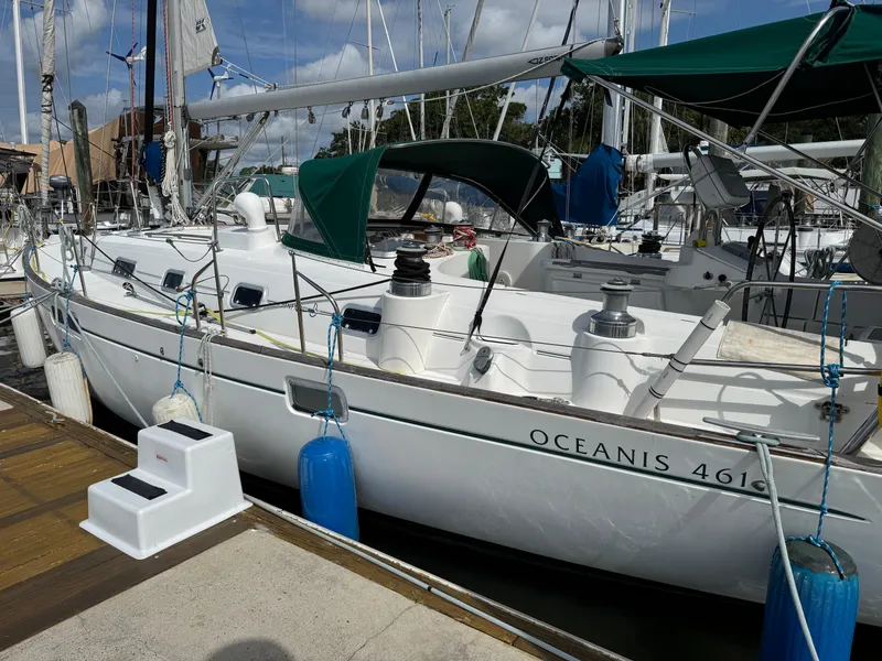 Slide: The Image of 1997 Beneteau Oceanis 461 sailboat docked, featuring green canopy and white hull. - 4