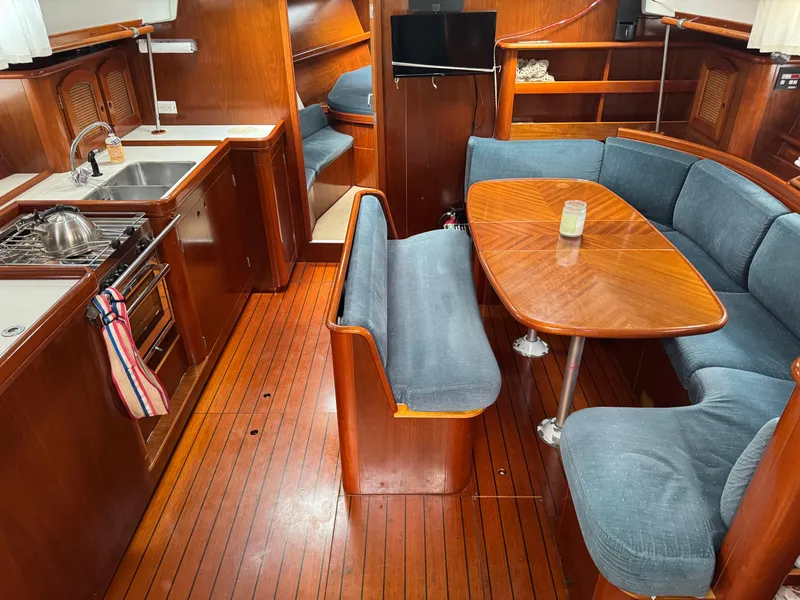 Slide: The Image of Interior of 1997 Beneteau Oceanis 461 yacht with wooden flooring and cozy seating area. - 6