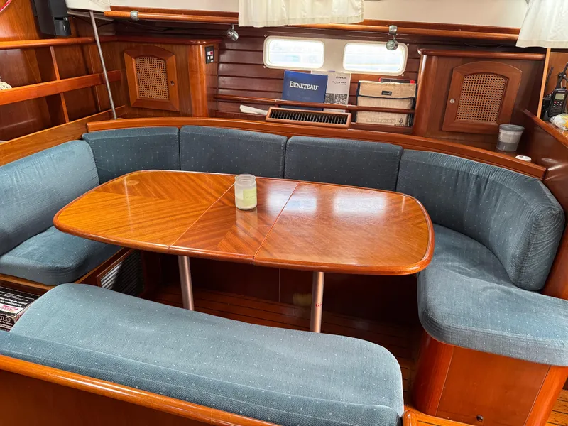 Slide: The Image of Interior of 1997 Beneteau Oceanis 461 sailboat with wooden table and blue cushioned seating. - 7