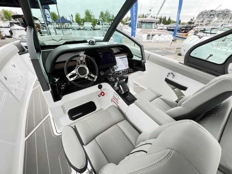 Slide: The Image of 2025 Monterey Elite 30 OB boat cockpit with modern steering and controls at marina. - 5