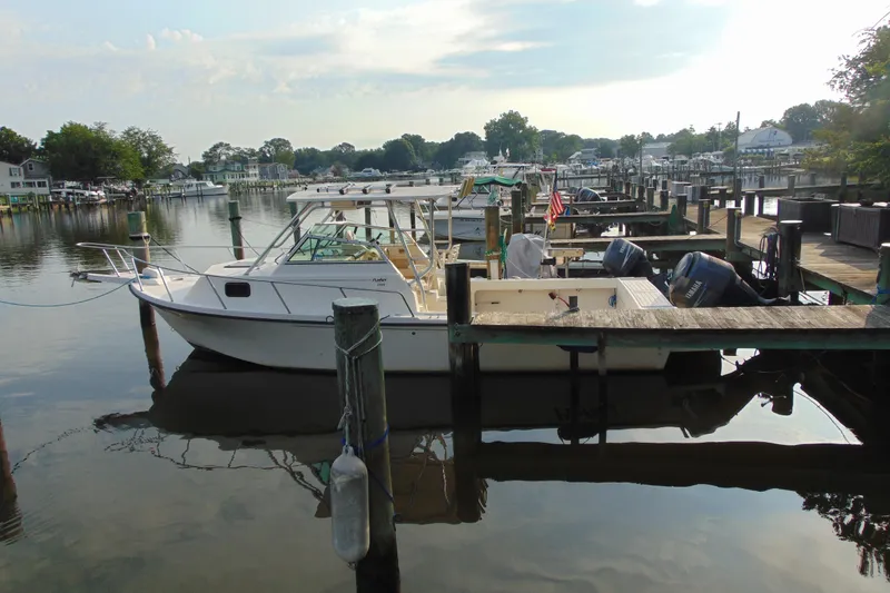 Slide: The Image of 2004 Parker Walkaround boat docked in a serene marina setting. - 11