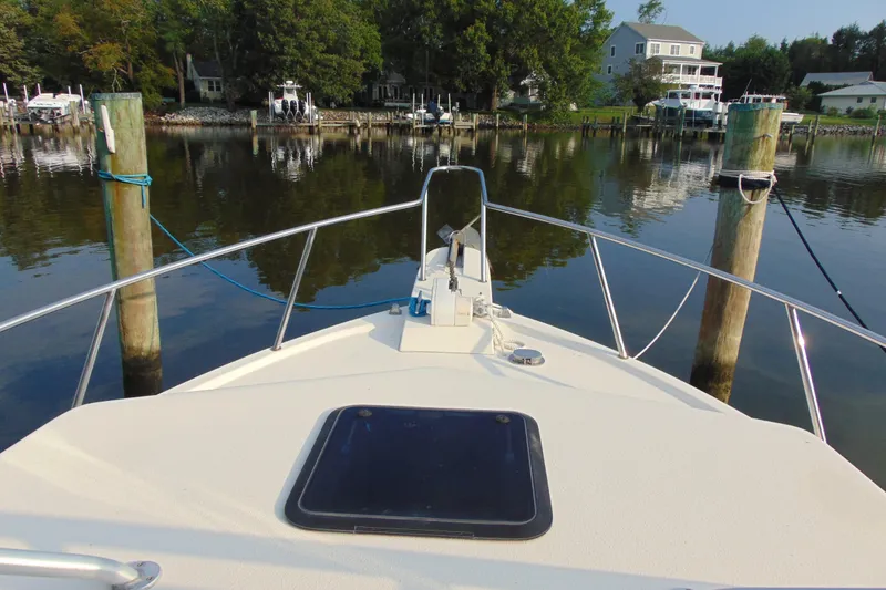 Slide: The Image of 2004 Parker Walkaround boat docked in a serene waterfront setting. - 16