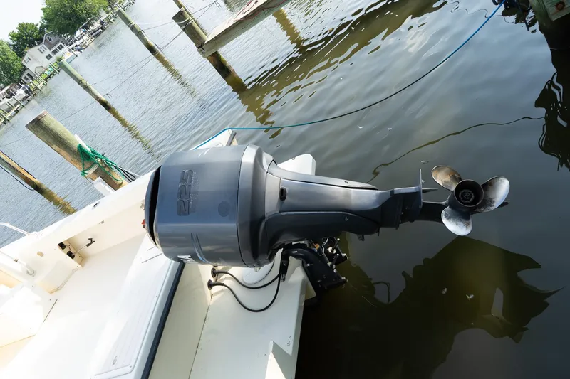Slide: The Image of Outboard motor on a 2004 Parker Walkaround boat docked by the water. - 21