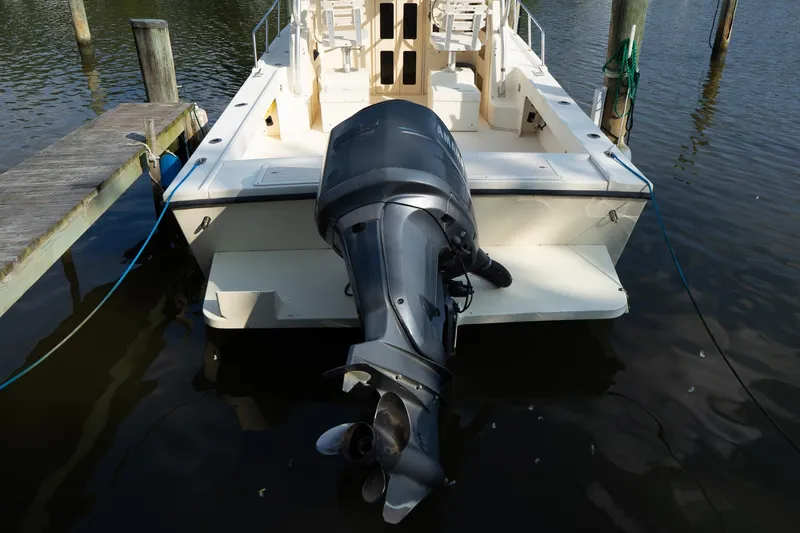 Slide: The Image of 2004 Parker Walkaround boat with outboard motor docked on calm water. - 22