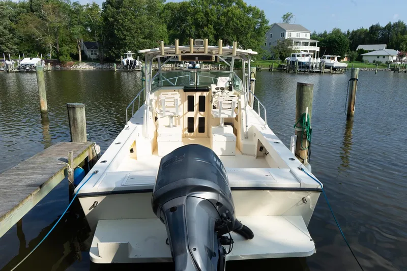 Slide: The Image of 2004 Parker Walkaround boat docked on a calm river with surrounding greenery. - 23