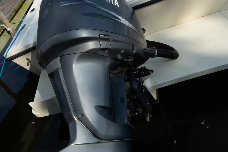 Slide: The Image of Outboard motor on a 2004 Parker Walkaround boat, docked by the water. - 24