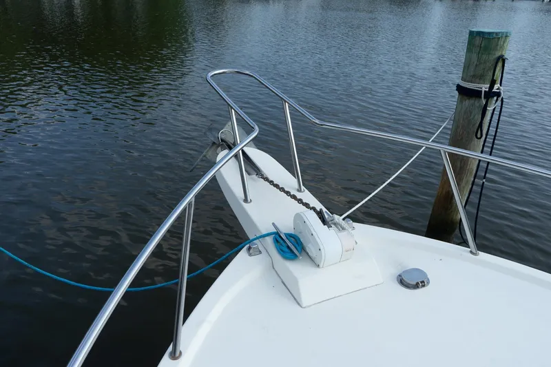 Slide: The Image of 2004 Parker Walkaround boat bow with anchor and railing on calm water. - 25