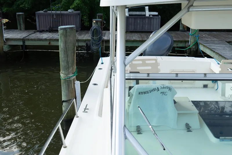 Slide: The Image of 2004 Parker Walkaround boat docked by wooden pier, with fishing gear visible. - 28