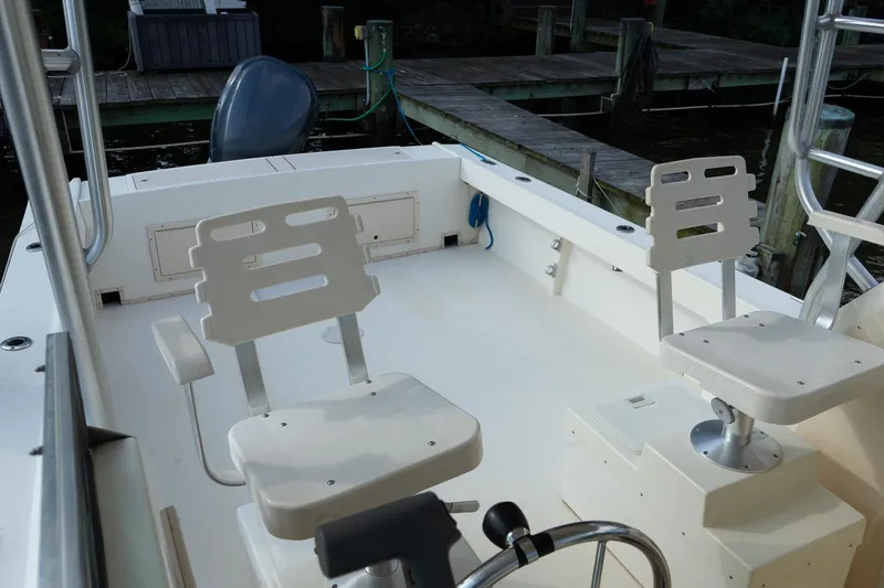 Slide: The Image of 2004 Parker Walkaround boat interior with swivel seats and docked at a marina. - 31