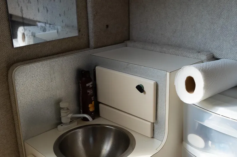 Slide: The Image of 2004 Parker Walkaround boat interior with sink, paper towel, and storage cabinet. - 38