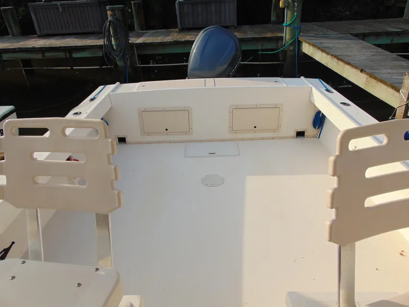 Slide: The Image of 2004 Parker Walkaround boat interior with seating and storage compartments at a dock. - 4