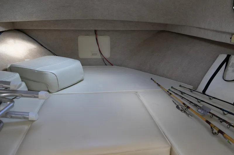 Slide: The Image of 2004 Parker Walkaround boat interior with fishing rods and cushioned seating. - 40