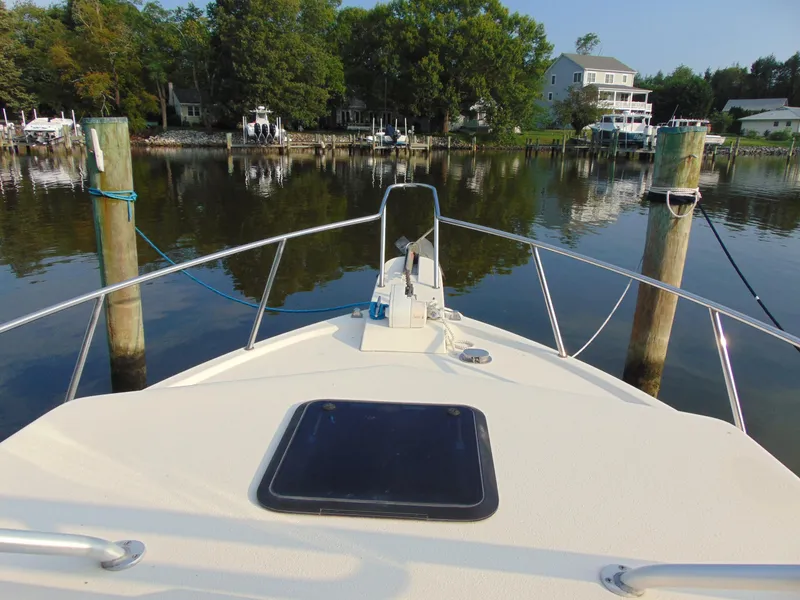 Slide: The Image of 2004 Parker Walkaround boat docked in a serene waterfront setting. - 5