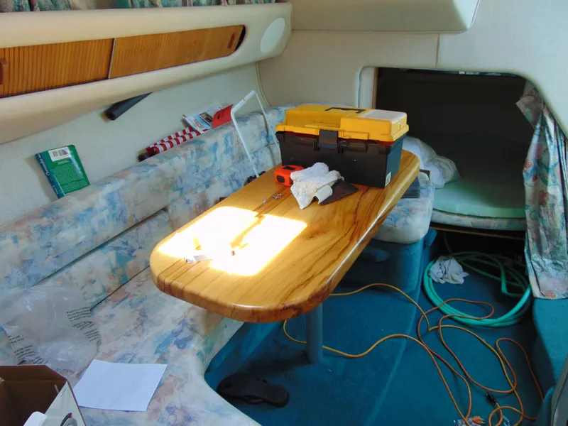 Slide: The Image of Interior of a 2004 Parker Walkaround boat with a wooden table and toolbox. - 8