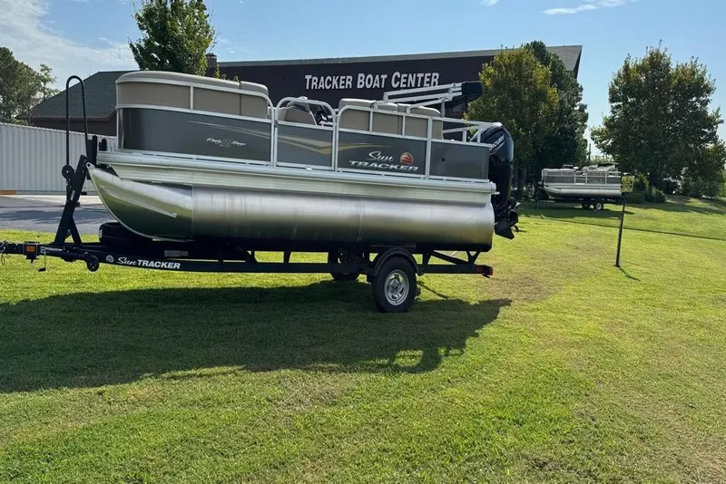 The Image of 2025 Sun Tracker Party Barge 18 DLX pontoon boat on trailer at dealership. - 2