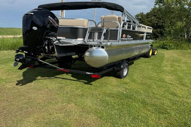 Slide: The Image of 2025 Sun Tracker Party Barge 18 DLX pontoon boat on grassy field. - 4