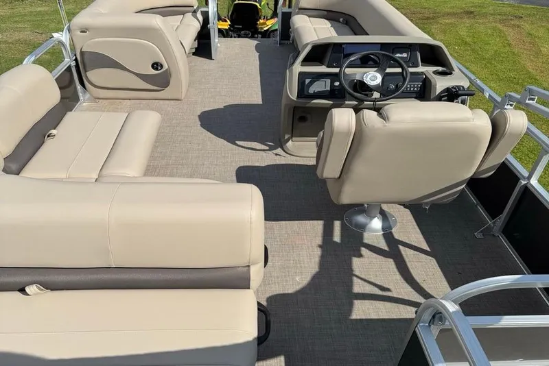 Slide: The Image of 2025 Sun Tracker Party Barge 18 DLX interior with beige seating and steering console. - 7