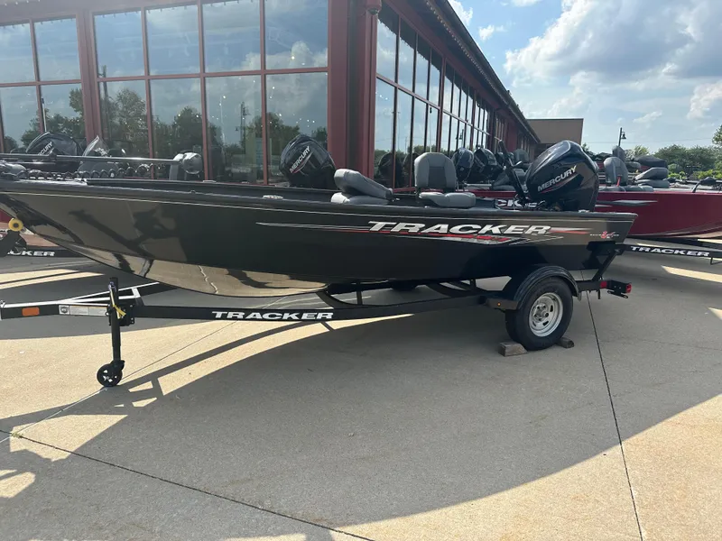Slide: The Image of 2025 Tracker Super Guide V-16 T boat on trailer, parked outdoors. - 2