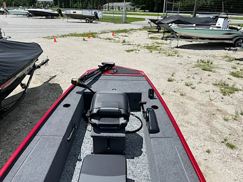 Slide: The Image of 2025 Tracker Panfish 17 boat in a gravel lot, featuring a central seat and steering controls. - 4