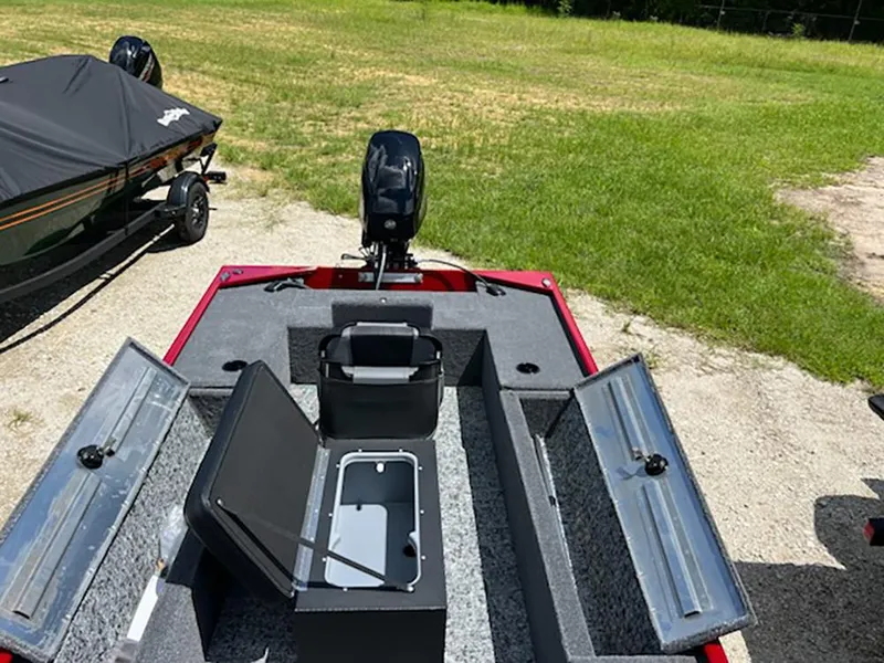 Slide: The Image of 2025 Tracker Panfish 17 boat with open storage compartments, parked on grass. - 6