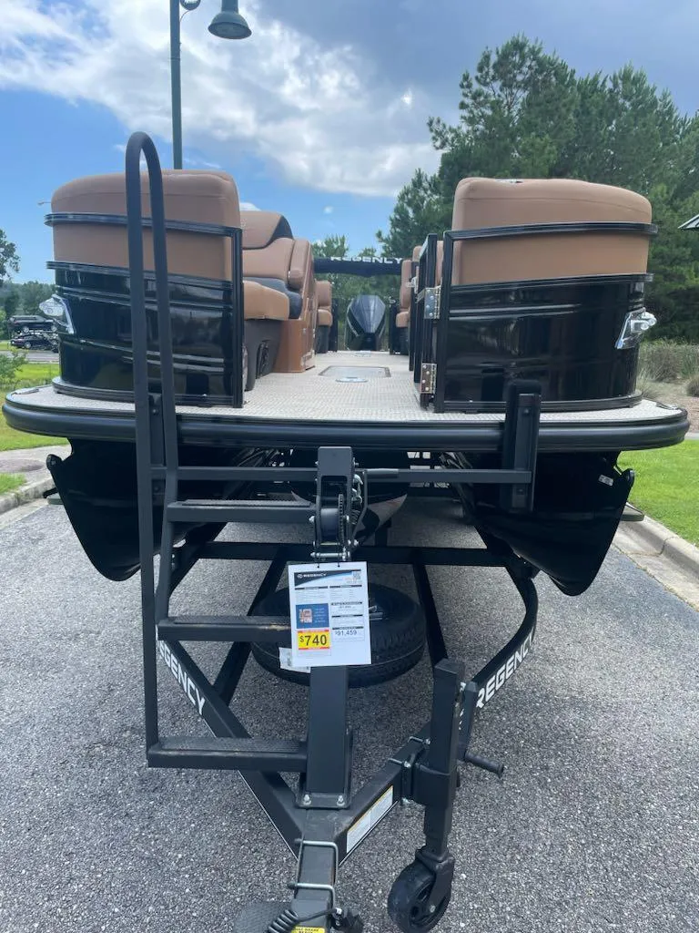Slide: The Image of 2025 Regency 230 LE3 pontoon boat on trailer, featuring tan seating and black exterior. - 3
