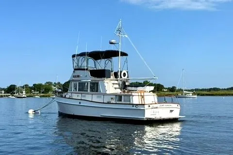 The Image of 1981 Grand Banks 36 Classic yacht anchored on calm water under clear blue sky. - 0